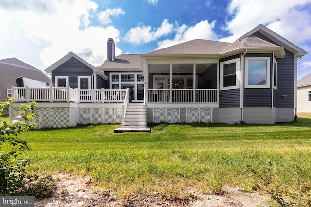 back of property featuring a lawn, a sunroom, and a deck