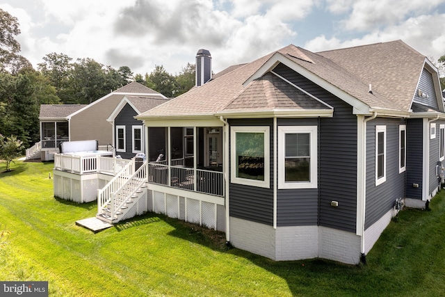 back of house featuring a deck, a sunroom, and a lawn