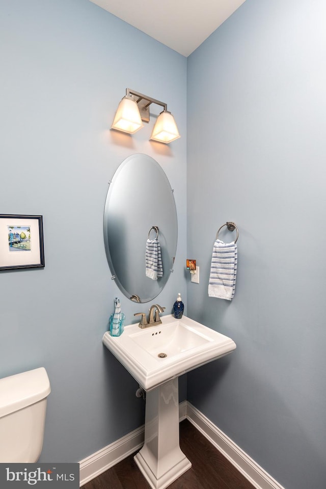 bathroom featuring wood-type flooring and toilet