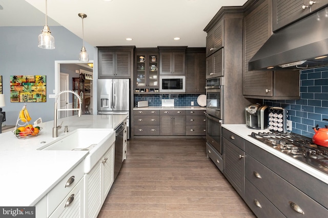 kitchen with white cabinets, tasteful backsplash, wood-type flooring, decorative light fixtures, and stainless steel appliances