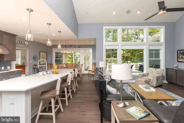 living room with ceiling fan, sink, dark hardwood / wood-style flooring, and a wealth of natural light