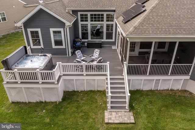 exterior space with a lawn, a hot tub, and a deck