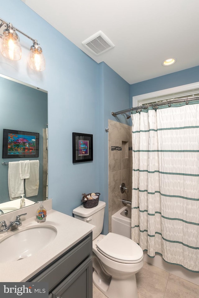 full bathroom featuring tile patterned flooring, vanity, toilet, and shower / bath combo with shower curtain