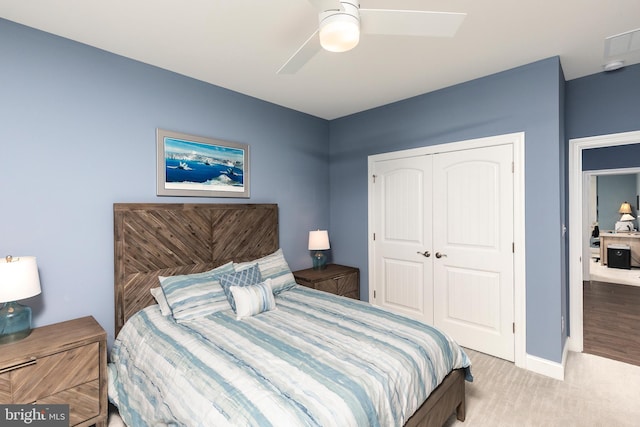 bedroom with a closet, ceiling fan, and light colored carpet