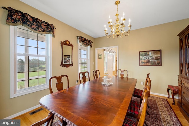 dining room with wood-type flooring and a notable chandelier