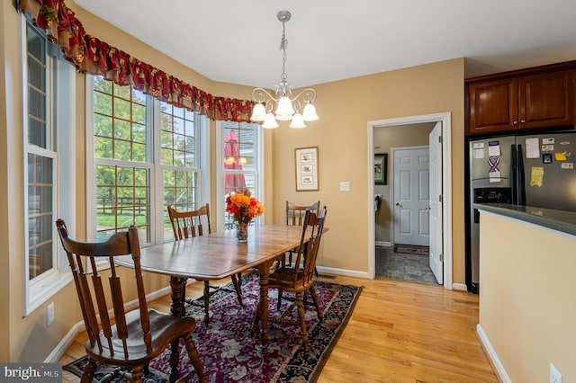 dining space featuring an inviting chandelier and light hardwood / wood-style flooring