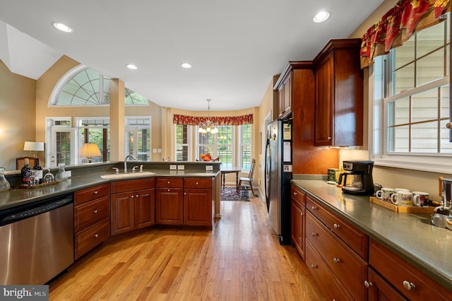 kitchen with stainless steel appliances, light wood-type flooring, a healthy amount of sunlight, and sink