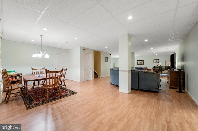 dining space featuring a paneled ceiling, an inviting chandelier, and hardwood / wood-style flooring