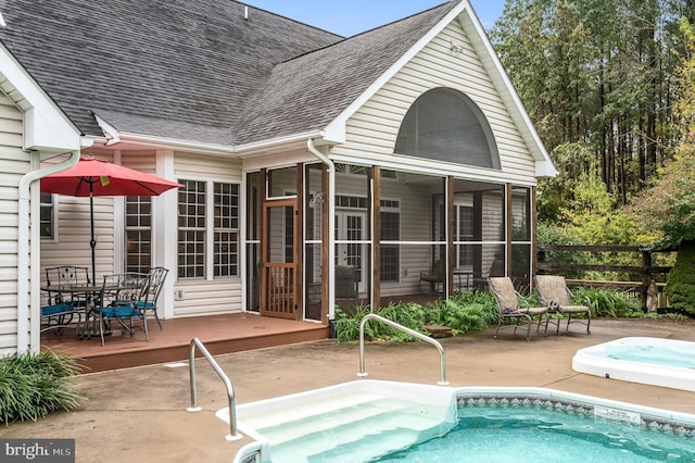 view of pool with a sunroom, a patio area, and a jacuzzi