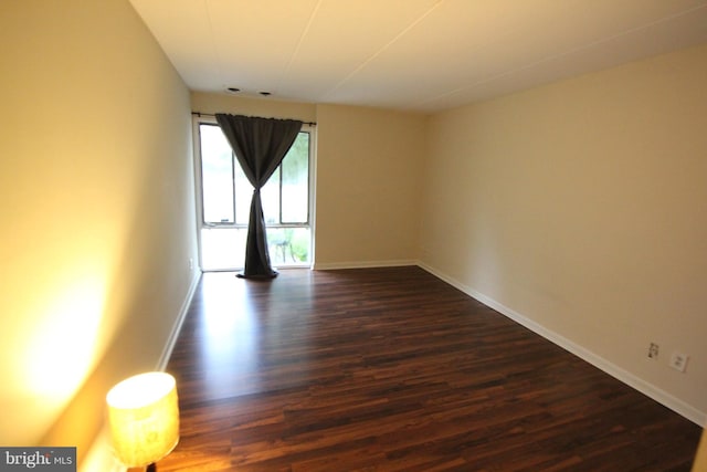 unfurnished room with dark hardwood / wood-style flooring