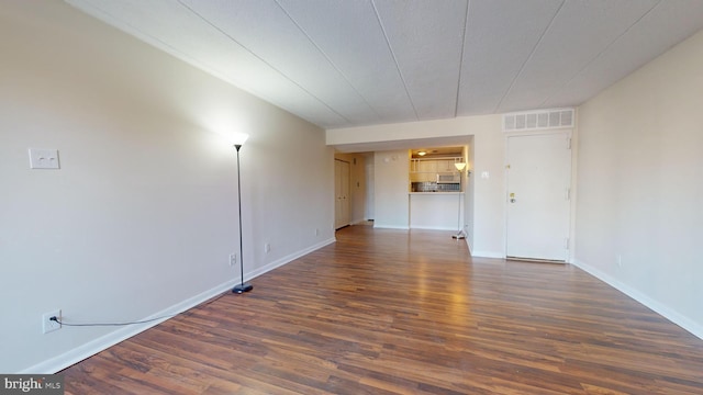 empty room with dark hardwood / wood-style flooring