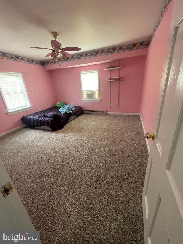 unfurnished bedroom with a baseboard radiator, ceiling fan, and carpet floors