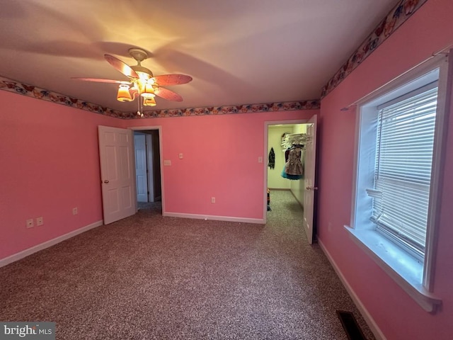 unfurnished bedroom featuring carpet, a spacious closet, ceiling fan, and a closet