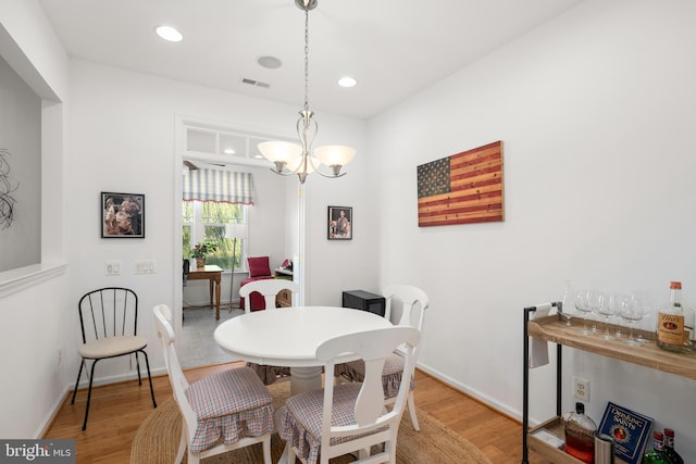 dining room featuring light wood-type flooring and a chandelier