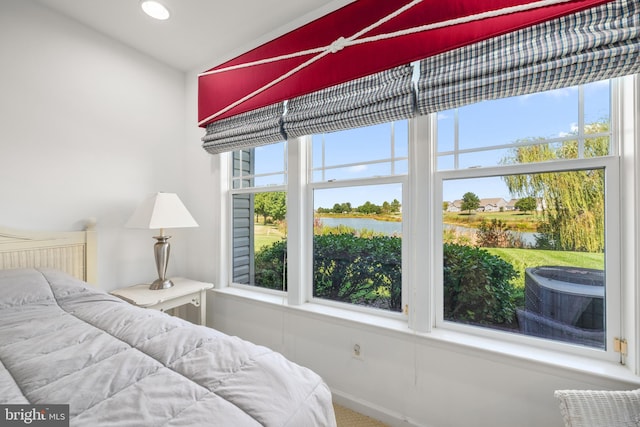 bedroom featuring carpet, a water view, and vaulted ceiling