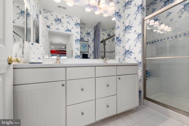 bathroom featuring tile patterned flooring, a shower with shower door, and vanity