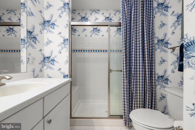 bathroom featuring vanity, toilet, a shower with door, and tile patterned floors