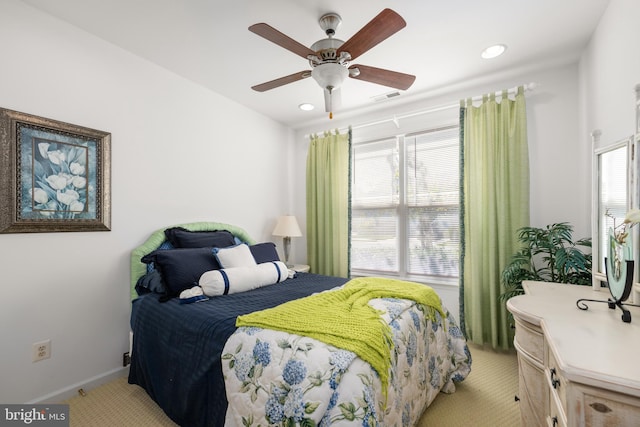 bedroom with multiple windows, light colored carpet, and ceiling fan