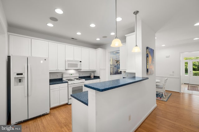 kitchen with hanging light fixtures, white cabinets, white appliances, kitchen peninsula, and light wood-type flooring