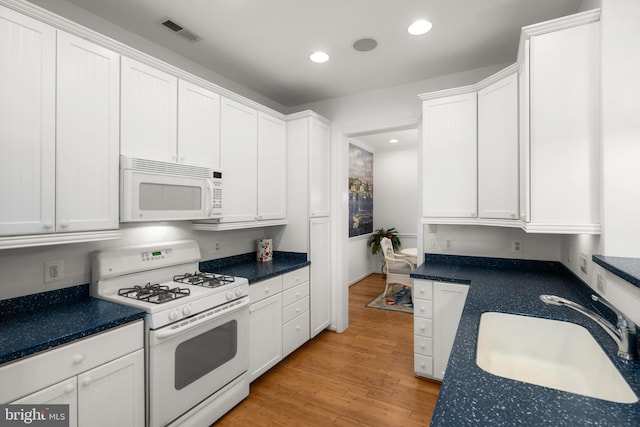 kitchen with white cabinets, sink, and white appliances