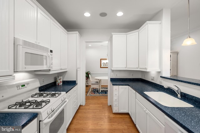 kitchen with white cabinetry, white appliances, pendant lighting, light hardwood / wood-style flooring, and sink