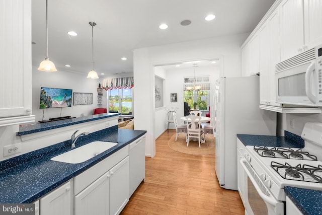 kitchen with light hardwood / wood-style flooring, white appliances, white cabinetry, and decorative light fixtures