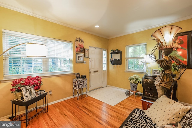 entrance foyer with ornamental molding and light hardwood / wood-style flooring