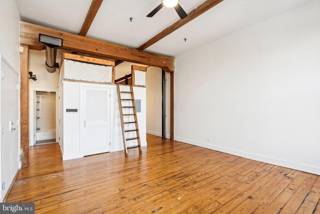 unfurnished bedroom with wood-type flooring and beam ceiling