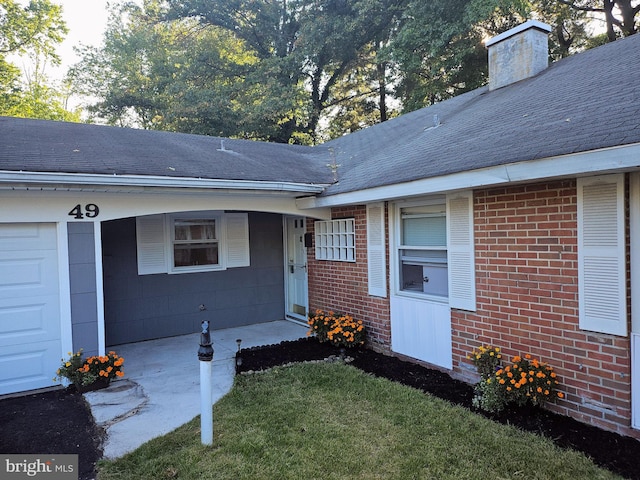 property entrance with a garage and a yard