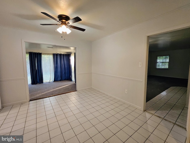 unfurnished room with plenty of natural light, ornamental molding, light tile patterned floors, and ceiling fan