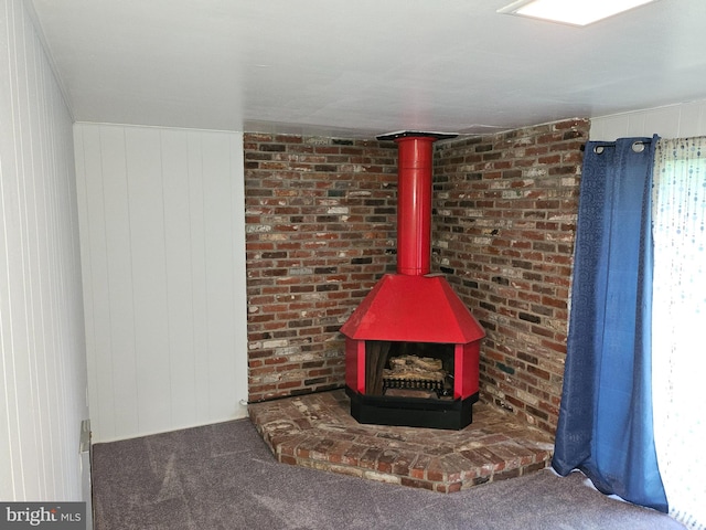 interior details with a wood stove, wooden walls, and carpet