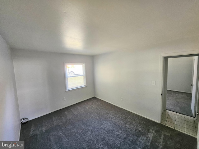 spare room with dark colored carpet