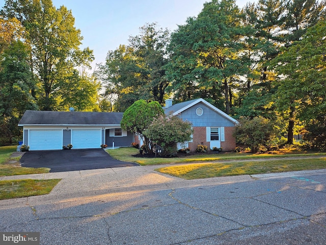 ranch-style home featuring a garage and a front lawn