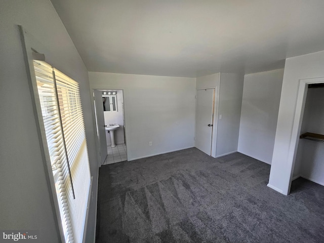 spare room featuring sink and dark carpet