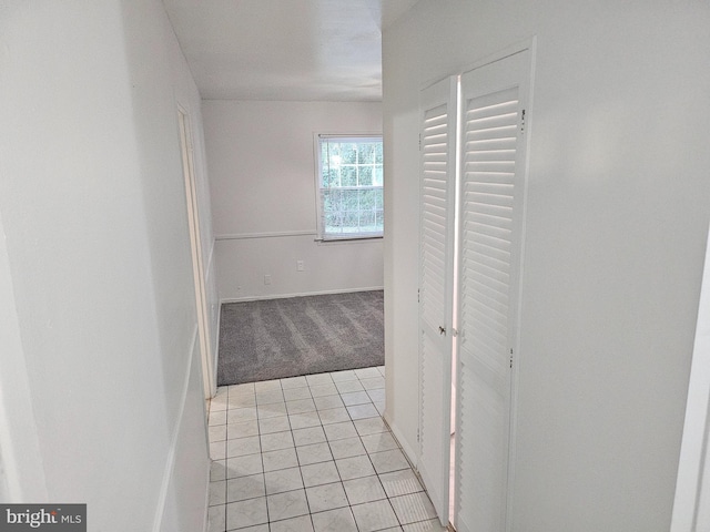 hallway featuring light colored carpet