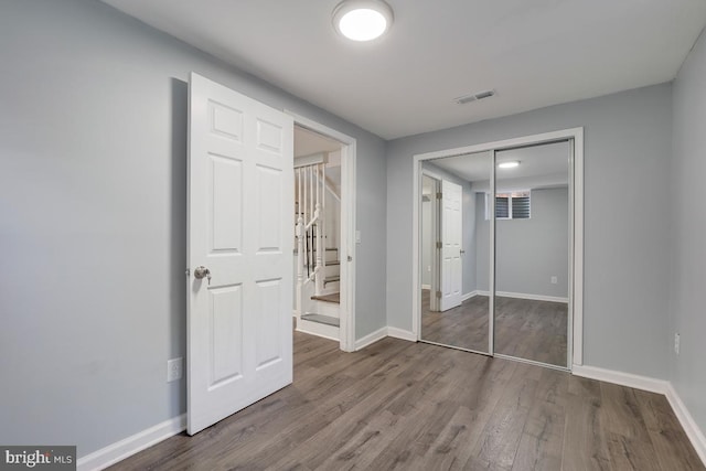 unfurnished bedroom featuring a closet and hardwood / wood-style flooring