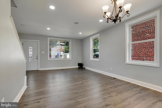 entrance foyer with dark wood-type flooring and a chandelier