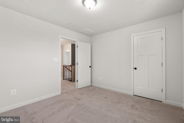 unfurnished room featuring light carpet