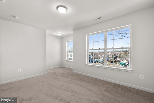 carpeted empty room featuring plenty of natural light