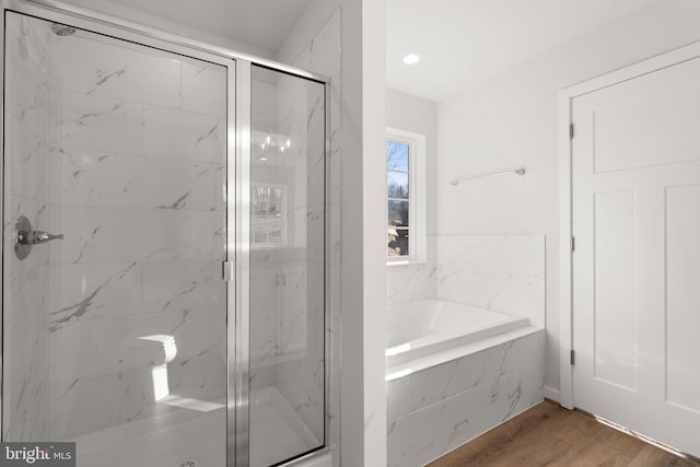 bathroom with independent shower and bath and wood-type flooring