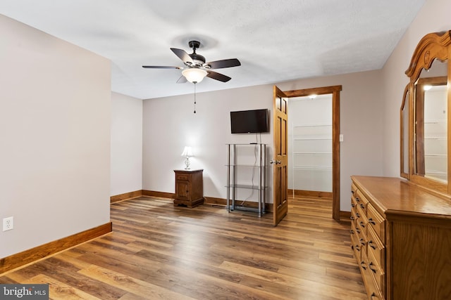 unfurnished bedroom with a textured ceiling, ceiling fan, and dark wood-type flooring