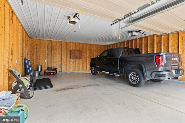 garage featuring wooden walls and a garage door opener