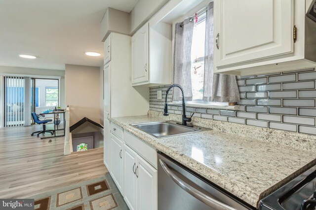 kitchen featuring light hardwood / wood-style flooring, white cabinets, dishwasher, and decorative backsplash