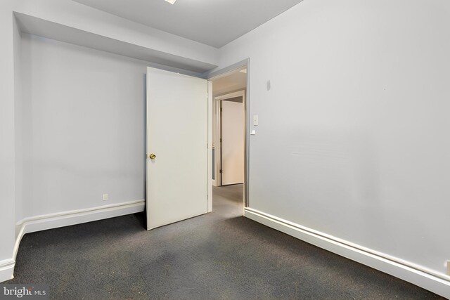 unfurnished bedroom with dark colored carpet