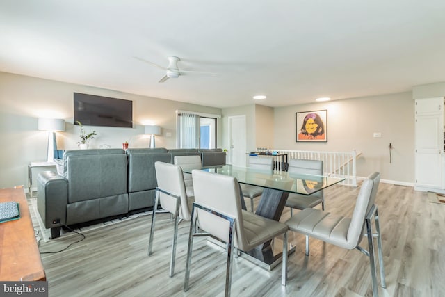 dining space with ceiling fan and light hardwood / wood-style flooring