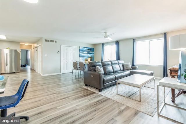 living room featuring light hardwood / wood-style floors and ceiling fan