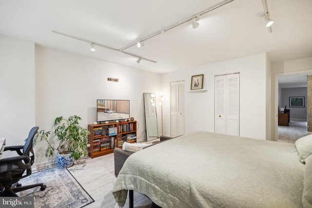 bedroom with light hardwood / wood-style flooring and rail lighting