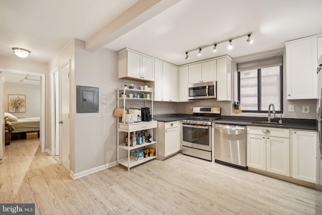 kitchen with white cabinets, appliances with stainless steel finishes, and sink