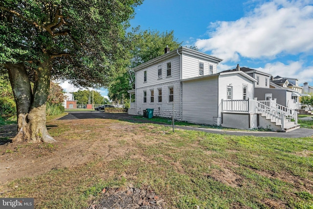 view of property exterior featuring a deck and a yard