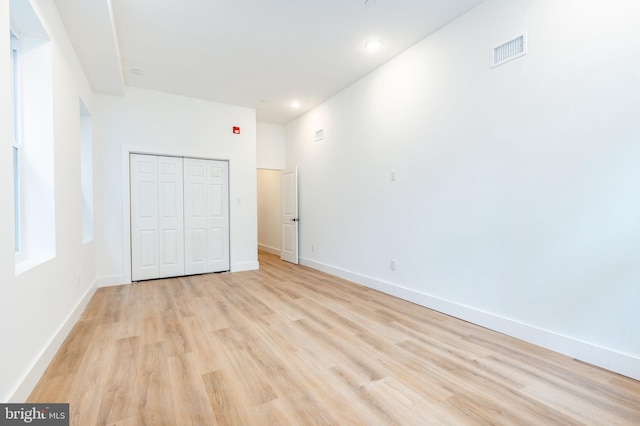 unfurnished bedroom with light hardwood / wood-style floors and a closet